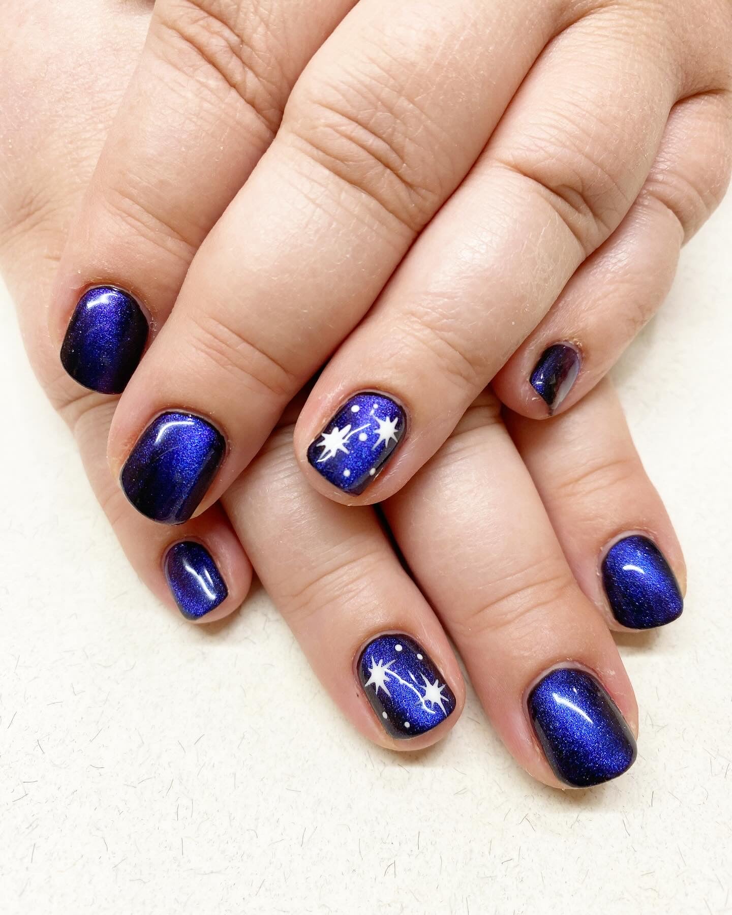 Vibrant blue nails with feature stary sky feature nail