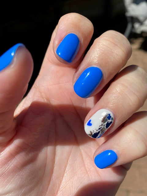 Blue nails with nail art in an outdoor setting